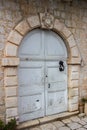 Old arch doors with peeled off paint in an old stone town