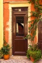 The old arch wooden door in the yellow stone house on the small pedestrianized paved street on the sunny day Royalty Free Stock Photo