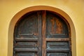 Old arch wooden door on yellow wall