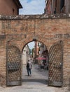 Old arched entrance to a park in Venice, Italy and man walking by Royalty Free Stock Photo