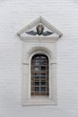 Old Arched Window With Metall Lattice And Relief On A White Brick Wall Of Christian Church