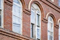 Old arched windows in a multi-story brick building with relief masonry of cornices and arches Royalty Free Stock Photo