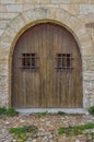 Old arched wooden door with barred windows Royalty Free Stock Photo