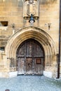 Old arched wooden medieval door with blazon