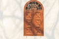 Old arched wooden window on white wall with shadows of tree bran Royalty Free Stock Photo