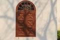 Old arched wooden window on white wall with shadows of tree bran Royalty Free Stock Photo