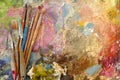 Old art brushes on a palette with paints. top view. Royalty Free Stock Photo