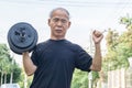 Old asia man with dumbbells. Person doing exercise outdoor.