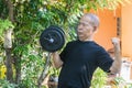 Old asia man with dumbbells. Person doing exercise outdoor.