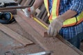 An old Asian carpenter is working to order in his own wood factory. With peace of mind by using hand tools including saws, wood Royalty Free Stock Photo