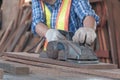 An old Asian carpenter is working to order in his own wood factory. With peace of mind by using hand tools including saws, wood Royalty Free Stock Photo