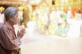 Old asian senior woman traveler tourist praying at buddhist temple Royalty Free Stock Photo