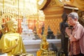 Old asian senior woman traveler tourist praying at buddhist temple Royalty Free Stock Photo