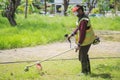 An old Asian gardener`s man post with lawnmowers before working in the garden Royalty Free Stock Photo