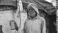 Old Asian man smiling and showing a green screen cell phone with rural village life concept background Royalty Free Stock Photo