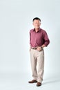 An old asian man wear red shirt and beige pants standing on studio white background. Isolated picture of happiness asian old man.