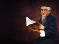 Old asian muslim prayer sitting and read holy al quran book Royalty Free Stock Photo