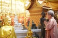 Old asian senior woman traveler tourist praying at buddhist temple Royalty Free Stock Photo