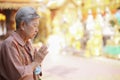 Old asian senior woman traveler tourist praying at buddhist temple Royalty Free Stock Photo