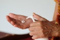 Old Asian Woman hands holding body lotion bottle and using cream for treatment skin in winter time.