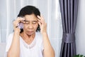 Old Asian woman having a headache hand holding eyeglasses feeling dizzy loss eye vision