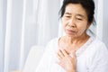 Old Asian woman having problem with shortness of breath, difficult breathing hand touching her chest