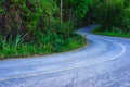 Old asphalt road curves into forest with winding road sign Royalty Free Stock Photo