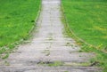 Old asphalt road overgrown with grass ascending a hill Royalty Free Stock Photo