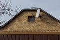 Old attic of a brown brick rural house with a small window Royalty Free Stock Photo