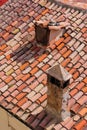 Old attic window and brick chimney on tile roof of a village house on sunny day. Vintage style roofing. Royalty Free Stock Photo