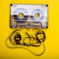 Old audio cassette with a tangled magnetic tape on a yellow back Royalty Free Stock Photo