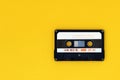 Old audio tape cassette on a bright yellow background. Top view, old technology concept Royalty Free Stock Photo