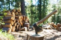 Old axe standing against a piled pieces of firewood Royalty Free Stock Photo