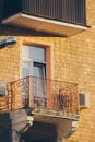 Old balcony with stucco and openwork fence near open window