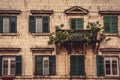 Old balcony with trees and flowers on old medieval building facade with windows in medieval architecture in ancient European city Royalty Free Stock Photo