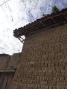 Old Balkan house wooden door and a clay wall. Vintage village clay bricks wall