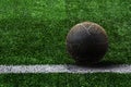 Old ball on artificial grass soccer field background. Royalty Free Stock Photo