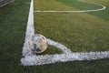 Old ball in new soccer field at corner Royalty Free Stock Photo