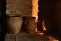 Old barbecue oven, with ancient clay pots and stone millstones. A jug of clay the stove