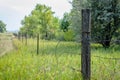 Old barbed wire fence stretched on weathered wood post Royalty Free Stock Photo