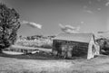 Old barn, garage and car in field black and white