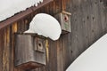 Old barn birdhouse covered in snow