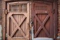 Old barn doors, with peeling paint, with two large metal locks on them Royalty Free Stock Photo