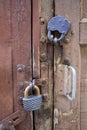 Old barn doors, with peeling paint, with two large metal locks on them Royalty Free Stock Photo
