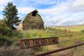 Old barn in Eastern Washington behind a rusty "no trespassing" sign