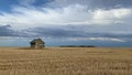 Old barn on the empty field after harvesting