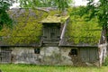 An old barn with a roof covered with moss Royalty Free Stock Photo