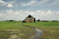 Old barn sitting isolated in an open corn field