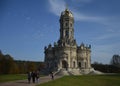 An old baroque orhodox church in a gold crown, on a sunny autumn day, a green park and people walking