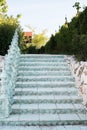 Old baroque stairs, outdoors. Stairs made of stone. Alley in beautiful garden with flowers and trees around.